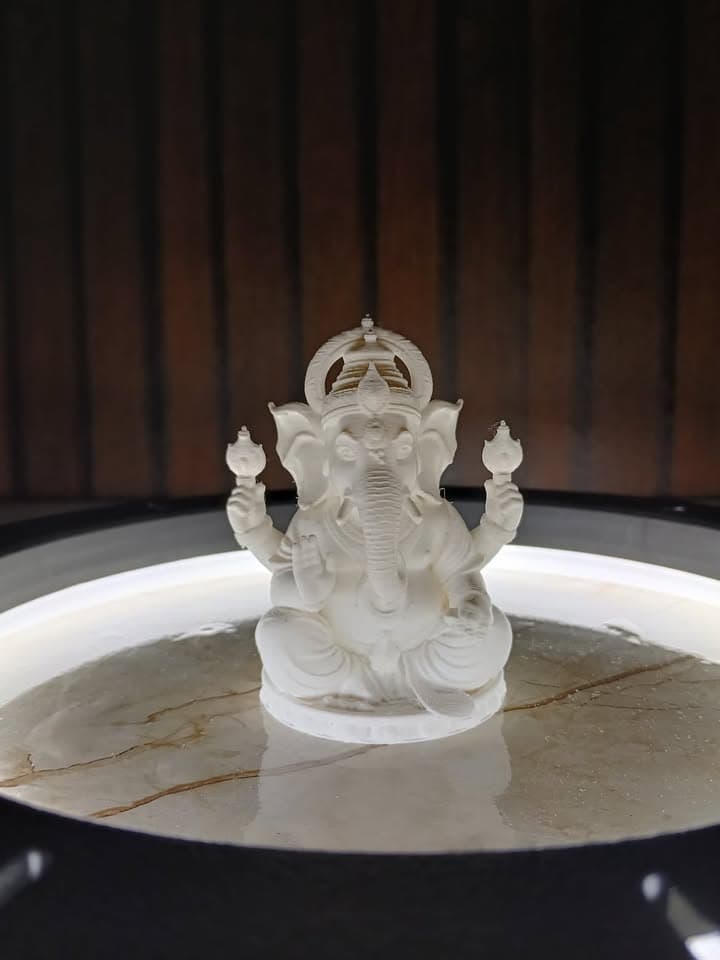 Ivory-white 3D-printed Ganesha idol displayed under a circular studio light